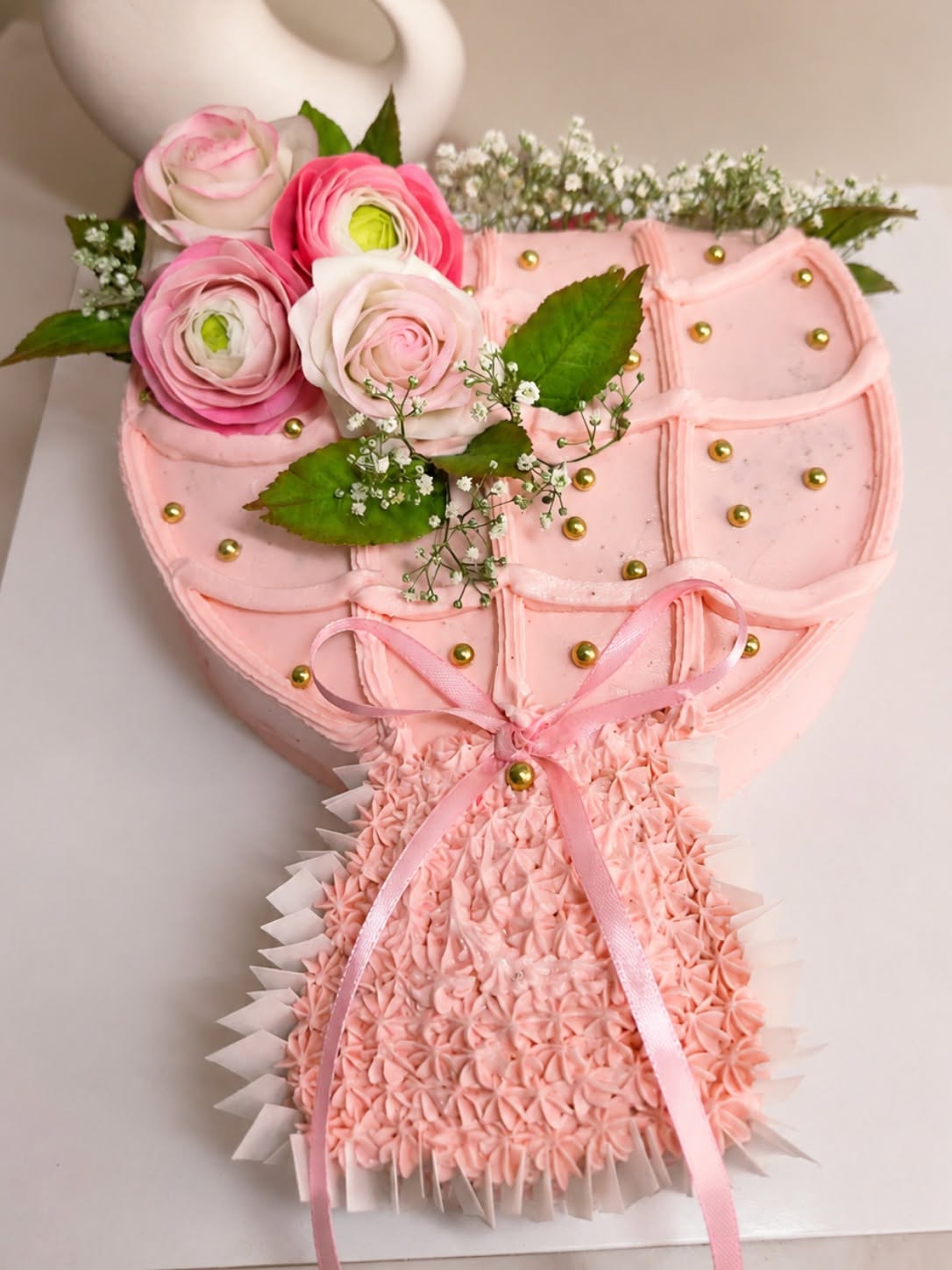 Pink rose bouquet celebration cake with a ribbon and gold details